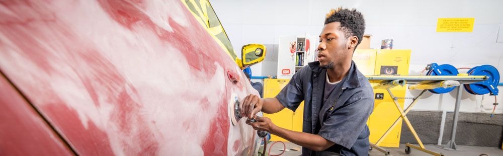 FDTC autobody repair student works on repairing a car in the paint shop