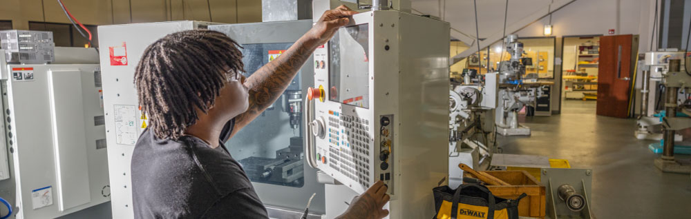 An FDTC student programs a CNC machine in the advanced manufacturing arena
