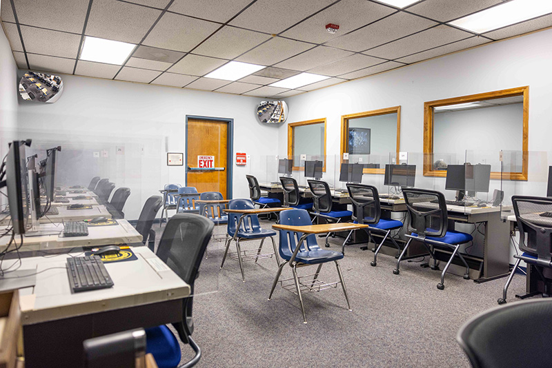 A picture of the testing center with desks, tables, and computers.